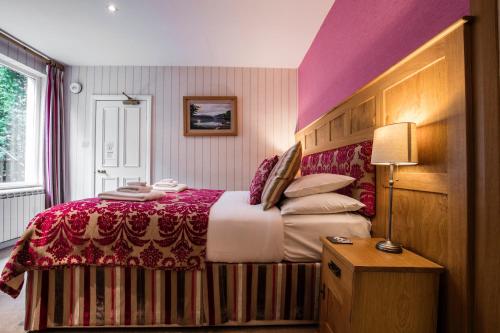 a bedroom with a bed with a red and white blanket at Yewfield Vegetarian Guest house in Ambleside