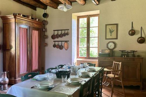 une salle à manger avec une grande table et de la vaisselle dans l'établissement La Couture, à Montferrand-du-Périgord