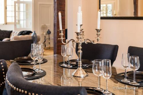 - une table à manger avec des verres à vin et des bougies dans l'établissement Suites Mana - MATAHINA avec VUE SUPERBE sur la Place DUCALE et Parking privé inclus, à Charleville-Mézières