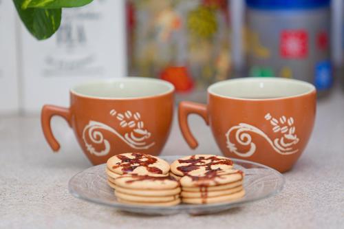 two cups of coffee and two pastries on a plate at Hilltop Retreat Matale in Matale