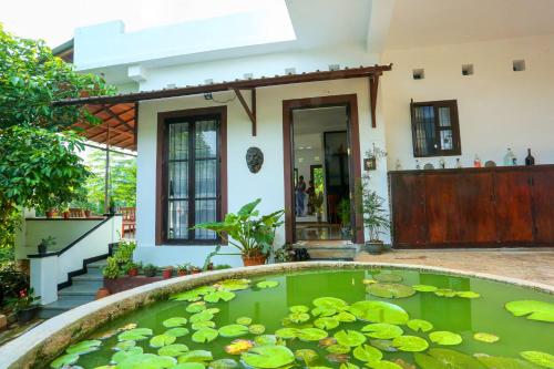a pond in front of a house with lilies at Hilltop Retreat Matale in Matale