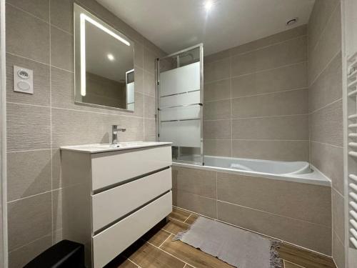 une salle de bain avec un lavabo et une baignoire dans l'établissement Maison au calme, à Sauveterre-de-Guyenne