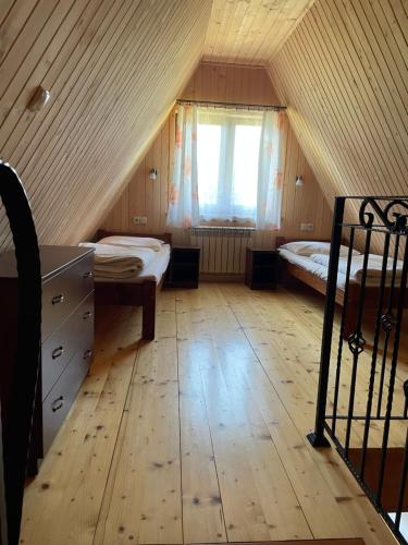 a attic room with two beds and a window at Felągówka in Murzasichle