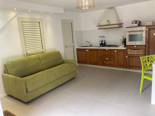 a living room with a green couch and a kitchen at “Molise” Four Seasons in San Massimo