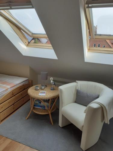 ein Schlafzimmer mit einem Bett, einem Stuhl und einem Tisch in der Unterkunft Ferienwohnung Tölle in Bad Rehburg