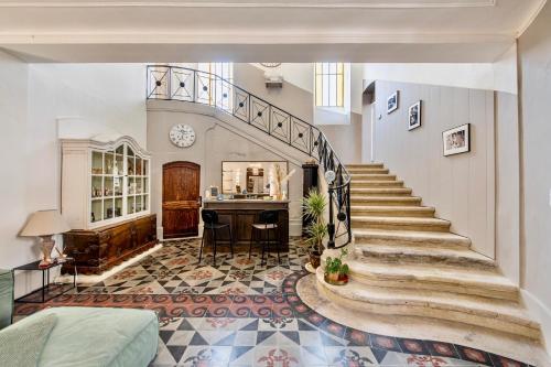 a living room with a staircase and a table at La Chapelle sur la Sorgue in LʼIsle-sur-la-Sorgue