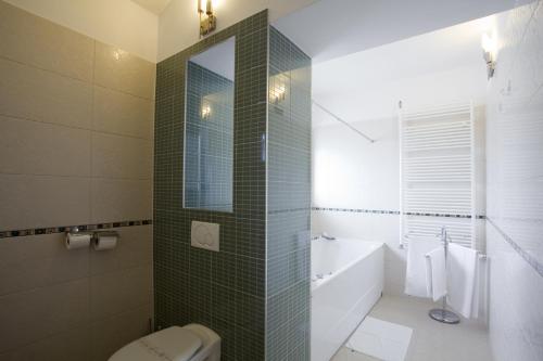 a bathroom with a shower and a toilet and a sink at Hotel Eden in Podstrana