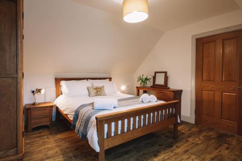 a bedroom with a bed with two towels on it at An Dòbhran - luxury self-catering in Dornie