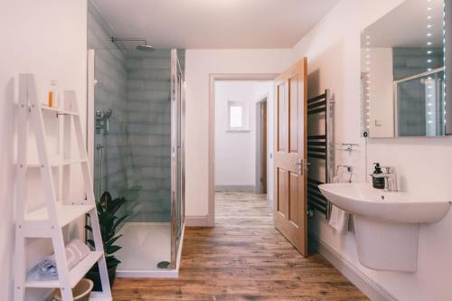 a bathroom with a sink and a shower and a mirror at An Dòbhran - luxury self-catering in Dornie