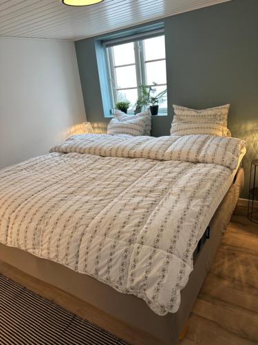 a bedroom with a large bed with a comforter at Charmerende stue lejlighed i centrum in Ringkøbing