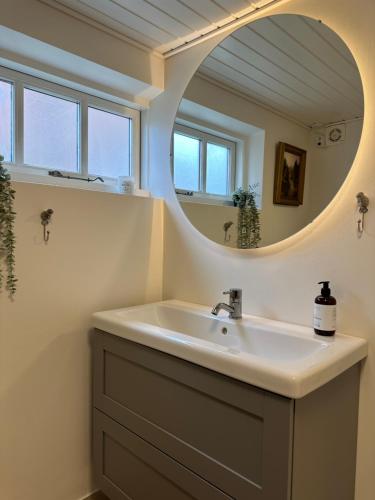 y baño con lavabo y espejo. en Charmerende stue lejlighed i centrum en Ringkøbing