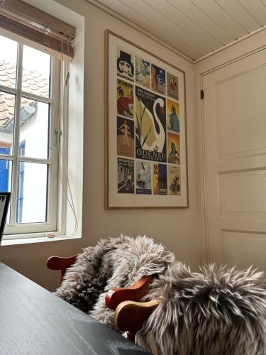 a room with a bed and a window with posters at Charmerende stue lejlighed i centrum in Ringkøbing
