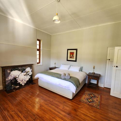 a bedroom with a large bed and a fireplace at Karoo Leeu Self Catering in Oudtshoorn