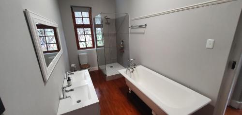 a white bathroom with a sink and a mirror at Karoo Leeu Self Catering in Oudtshoorn