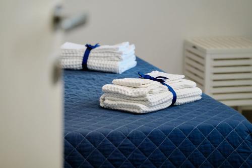 a stack of towels sitting on a bed at Riflessi DaMare Room & Apartment in Salerno