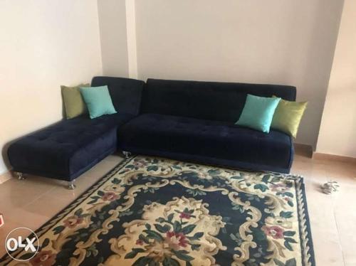 a living room with a blue couch and a rug at شاليه مكيف بقريه الأندلسيه in Marsa Matruh