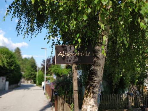 um sinal numa árvore ao lado de uma rua em Alpendohle Apartments Innsbruck em Innsbruck