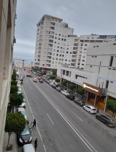 vistas a una calle con coches y edificios en Apparemment tanger enface hôtel el oumnia puerto en Tánger