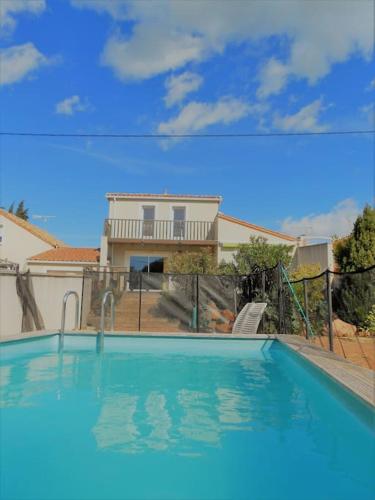 une grande piscine bleue devant une maison dans l'établissement Grande villa neuve avec piscine près mer et Sète, à Balaruc-les-Bains