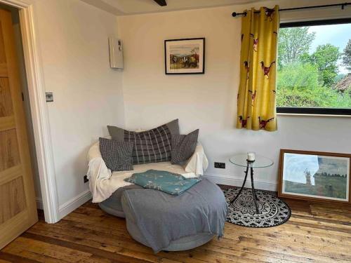 a living room with a couch and a window at Borthwick Farm Cottage Pottery in Borthwick