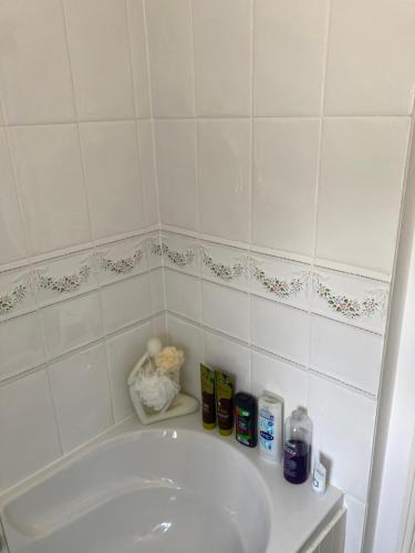 een badkamer met een wit bad en een wastafel bij The Welcome Home in Sleaford
