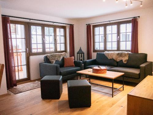 a living room with two couches and a table at stettli resort in Parpan