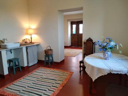 a living room with a table with a vase of flowers on it at Quinta do Passal in Arega
