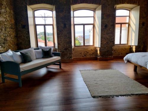 a living room with a couch and a bed and windows at Quinta do Passal in Arega