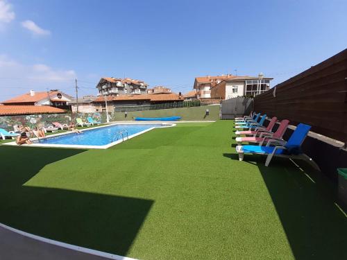 a swimming pool with chairs on the roof of a building at Hotel Los Nogales in Noja