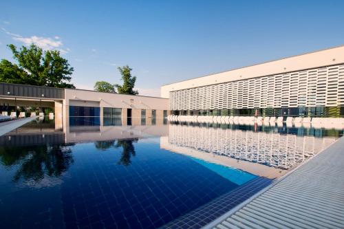 Hotel Castello & Thermal Spa Siklós في سيكلوس: مسبح امام مبنى
