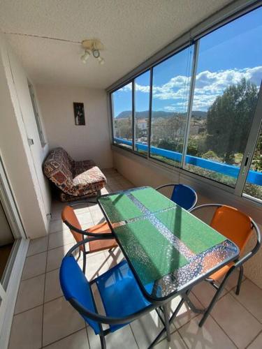 une table et des chaises dans une pièce avec une fenêtre dans l'établissement T2 agréable proche de la mer (mar vivo-sablettes), à La Seyne-sur-Mer