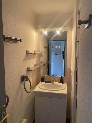 une salle de bain blanche avec un lavabo et un miroir dans l'établissement T2 agréable proche de la mer (mar vivo-sablettes), à La Seyne-sur-Mer