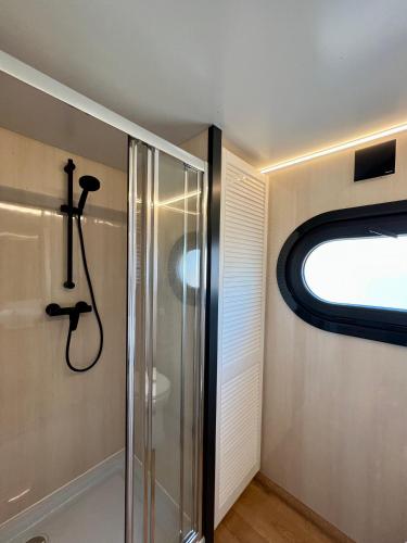 a bathroom with a shower and a window at NEW - Little Asia - Stunning Boathouse on a lake Near Amsterdam with Sauna in Vinkeveen