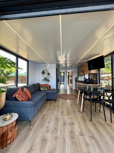 a living room with a blue couch and a table at NEW - Little Asia - Stunning Boathouse on a lake Near Amsterdam with Sauna in Vinkeveen