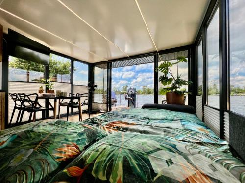 een slaapkamer met een bed en uitzicht op het water bij NEW - Little Asia - Stunning Boathouse on a lake Near Amsterdam with Sauna in Vinkeveen