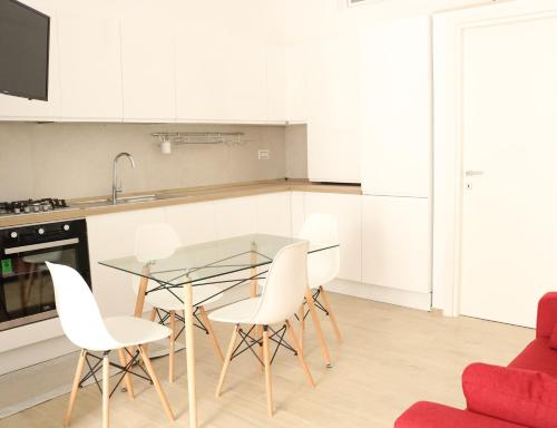 a kitchen with a glass table and white chairs at Dimora Vanni "civico 5" "civico 9" in Polignano a Mare