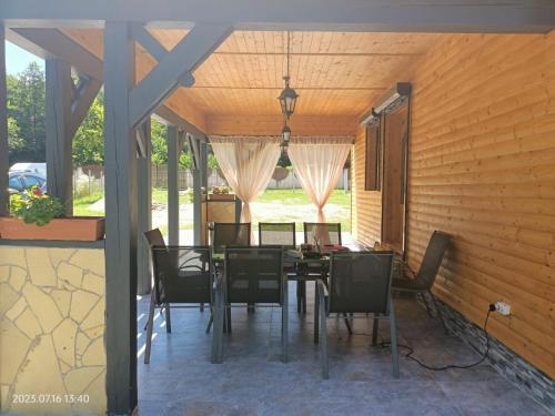 uma sala de jantar com uma mesa e cadeiras num pátio em ART House Transylvania , Valea Avrigului , Sibiu em Avrig