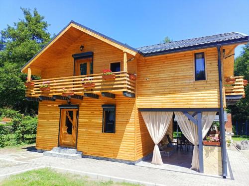 uma casa de madeira com uma varanda e um alpendre em ART House Transylvania , Valea Avrigului , Sibiu em Avrig