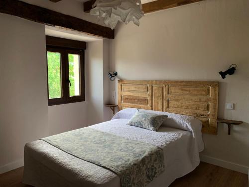 的住宿－Casa Lina，一间卧室配有一张带木制床头板的床和窗户。