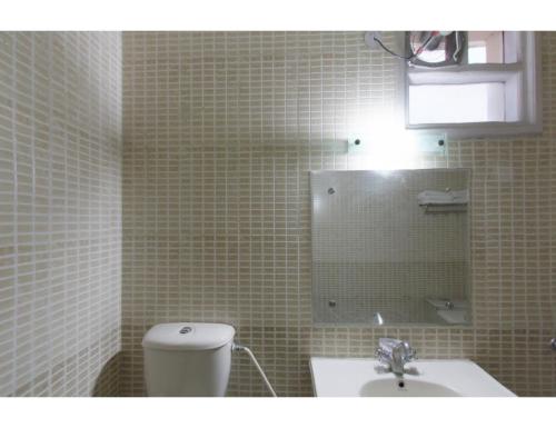 a bathroom with a toilet and a sink and a mirror at Vishal Hotel, Katra in Katra