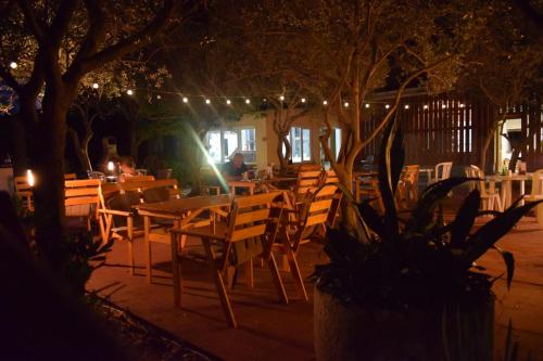 a restaurant with wooden tables and chairs at night at Panorama Apartments in Povljana