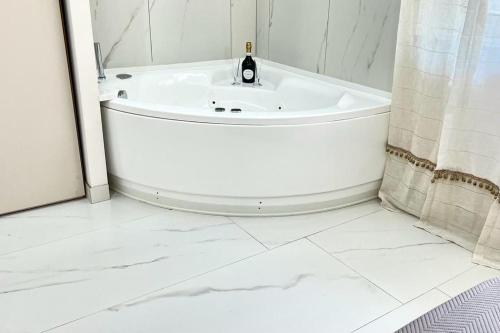 a white bathroom with a bath tub and a sink at Perle di Sicilia in Milazzo