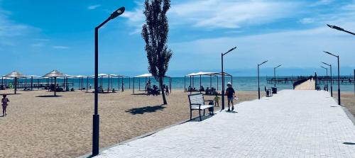 a beach with umbrellas and people on the beach at Apartment, Центр Отдыха Atlantis, Сары-Ой, 1-й этаж in Chon-Sary-Oy