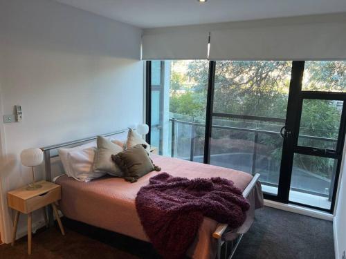 a bedroom with a bed and a large window at Large Executive 3 bedroom in Yarralumla