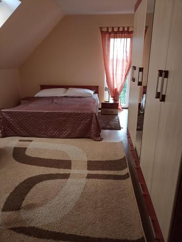 1 dormitorio con cama, ventana y alfombra en SANDRA, en Stare Bielice