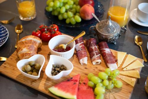 a tray of food with meats and fruit on a table at Apartments Allegra in Sinj