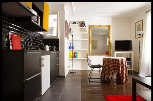 une cuisine avec une table et une chaise dans une pièce dans l'établissement Appartement proche Montmartre, à Paris