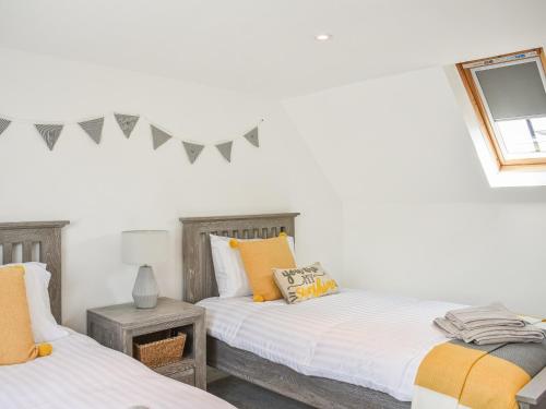 Duas camas num quarto com paredes brancas em Jock Mcmuffin Cottage em Portknockie