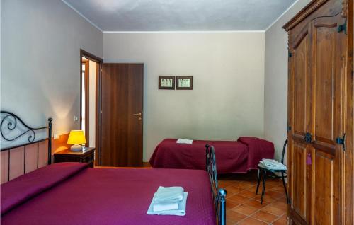 ApecchioにあるValguerriera 7- Rosa Rossaのベッドルーム1室(ベッド2台、ランプ付きテーブル付)