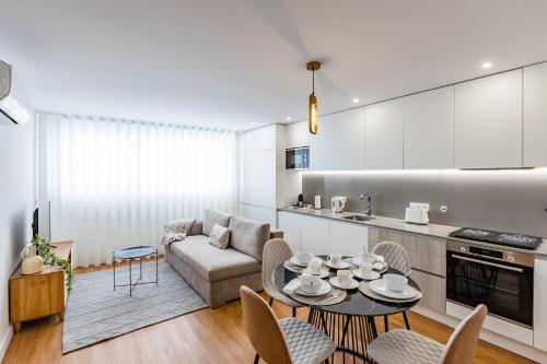 uma cozinha e sala de estar com uma mesa e um sofá em Pestana Apartments - In city center, Modern, New and Cozy no Porto